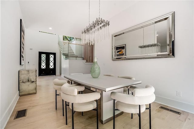 dining room with light hardwood / wood-style flooring and an inviting chandelier