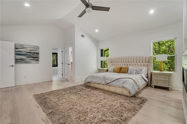 bedroom featuring high vaulted ceiling, light wood-type flooring, ceiling fan, and connected bathroom