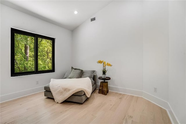 living area featuring lofted ceiling and light wood-type flooring