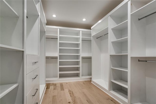 walk in closet with light hardwood / wood-style flooring