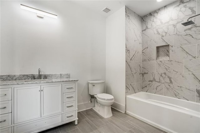 full bathroom with tile patterned flooring, tiled shower / bath combo, toilet, and vanity