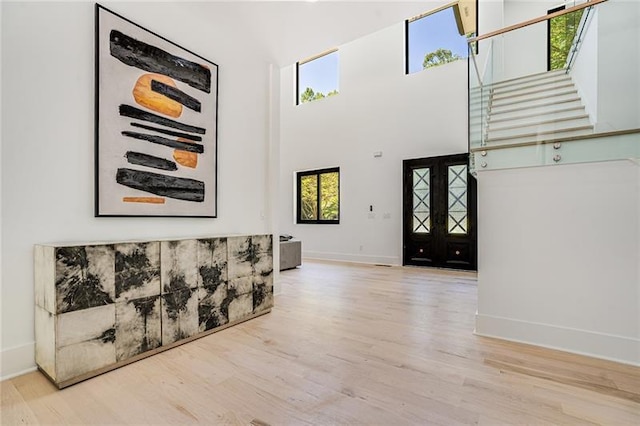 foyer featuring hardwood / wood-style flooring and a towering ceiling