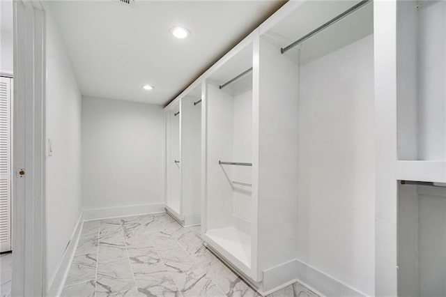 walk in closet with light tile patterned floors