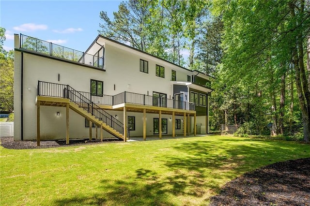 rear view of property with a deck and a yard