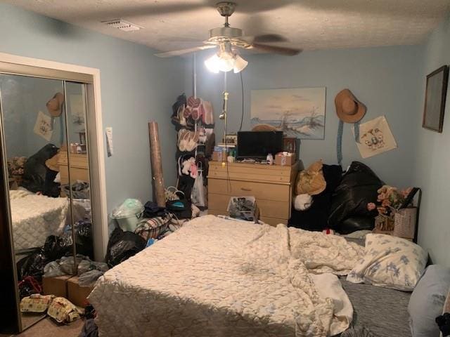 bedroom featuring a ceiling fan, visible vents, and a closet