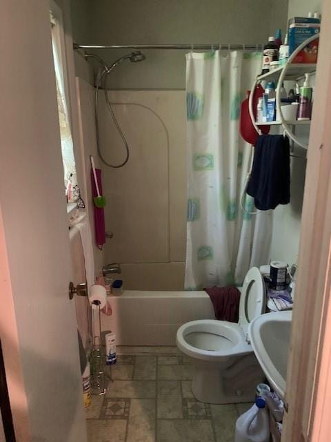 bathroom featuring toilet, shower / bath combination with curtain, and a sink