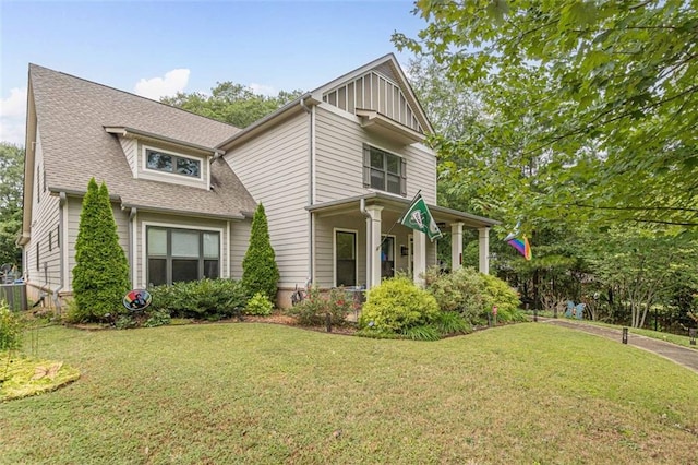 view of front of property with a front lawn and a shingled roof