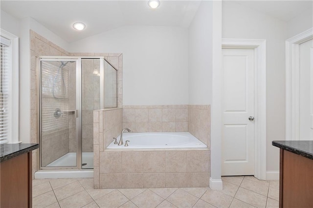 bathroom featuring plus walk in shower, vanity, tile patterned floors, and lofted ceiling
