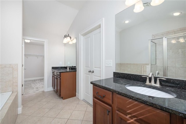 bathroom featuring tile patterned flooring, vanity, vaulted ceiling, and separate shower and tub