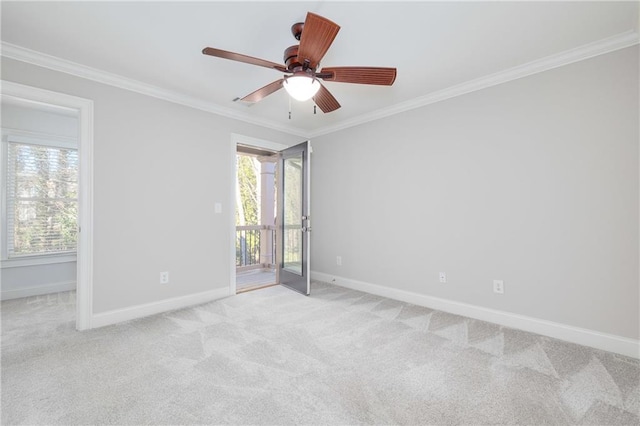 carpeted spare room with ceiling fan, a healthy amount of sunlight, and ornamental molding