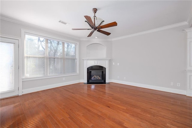unfurnished living room with plenty of natural light, ornamental molding, and ceiling fan