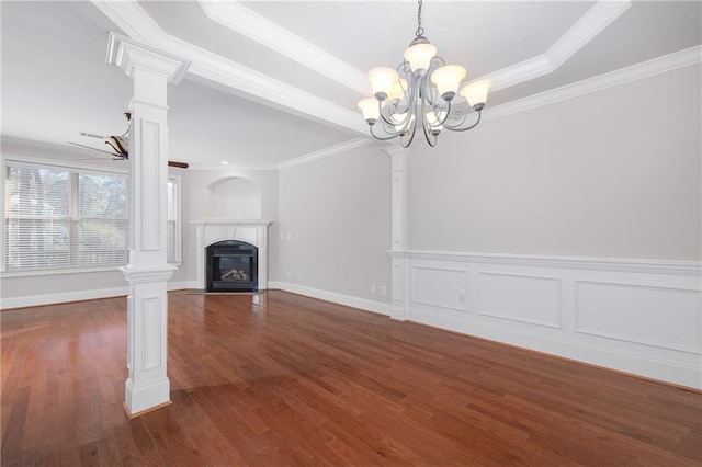 unfurnished living room with ornate columns, a raised ceiling, dark hardwood / wood-style floors, crown molding, and ceiling fan with notable chandelier
