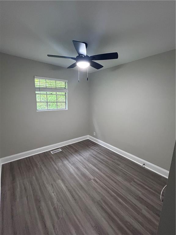 209 Trade Way, Dalton, GA 30721 - spare room featuring dark wood finished floors, baseboards, visible vents, and ceiling fan