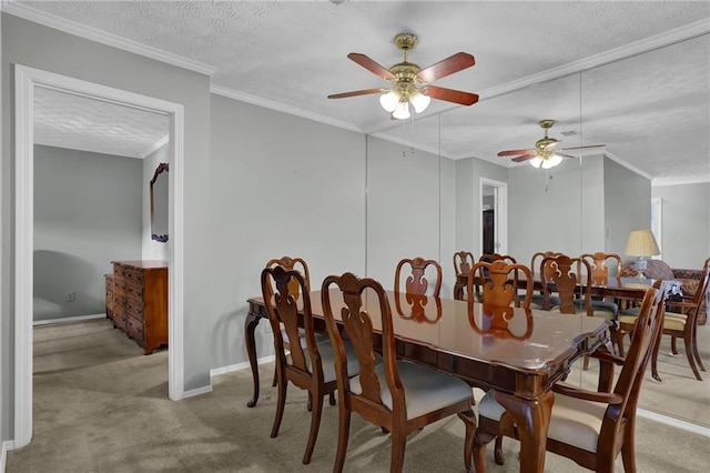 dining space with ceiling fan, light colored carpet, ornamental molding, and a textured ceiling