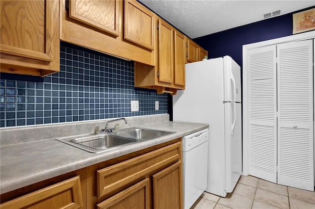 kitchen featuring sink, a textured ceiling, light tile patterned floors, white dishwasher, and backsplash