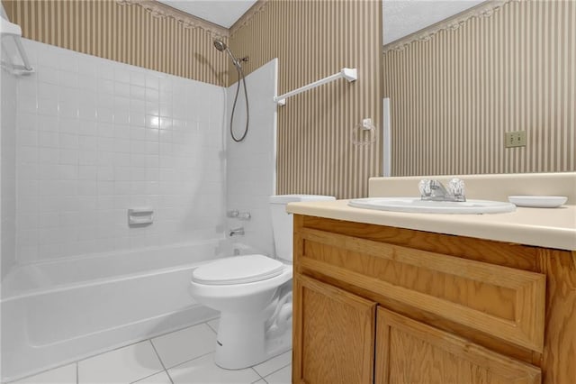 full bathroom featuring tile patterned flooring, vanity, a textured ceiling, toilet, and tiled shower / bath