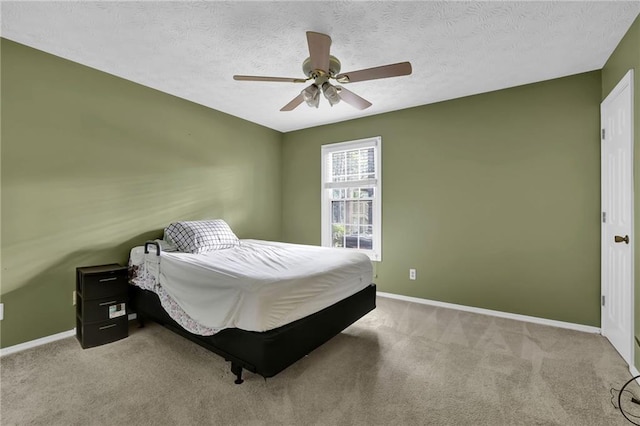 carpeted bedroom with ceiling fan and a textured ceiling