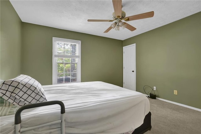 bedroom featuring ceiling fan, carpet, and a textured ceiling