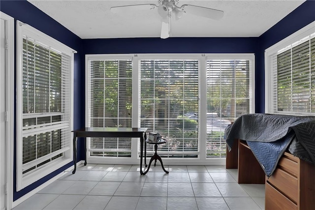 sunroom / solarium featuring a healthy amount of sunlight and ceiling fan