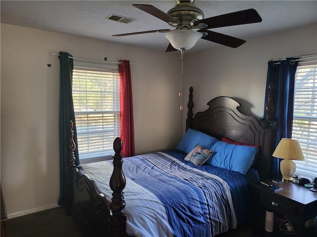 bedroom with ceiling fan and multiple windows