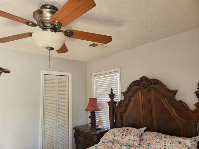 bedroom with a textured ceiling, a closet, and ceiling fan