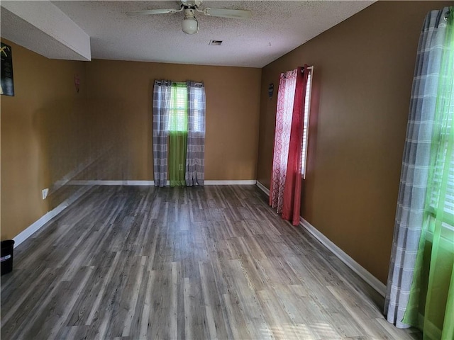 spare room with hardwood / wood-style floors, ceiling fan, and a textured ceiling