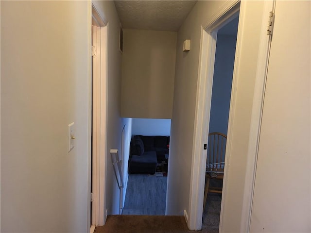 hall with carpet and a textured ceiling