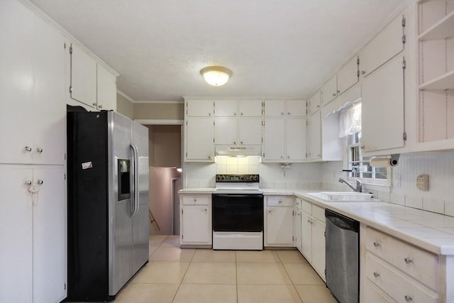 kitchen featuring white cabinets, appliances with stainless steel finishes, light tile patterned floors, and sink