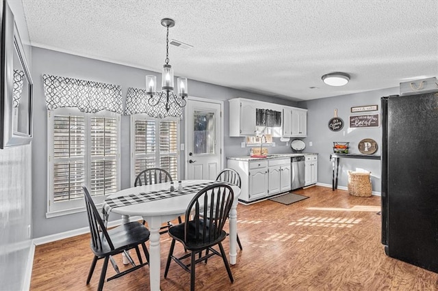 dining room featuring light hardwood / wood-style floors, sink, and a notable chandelier