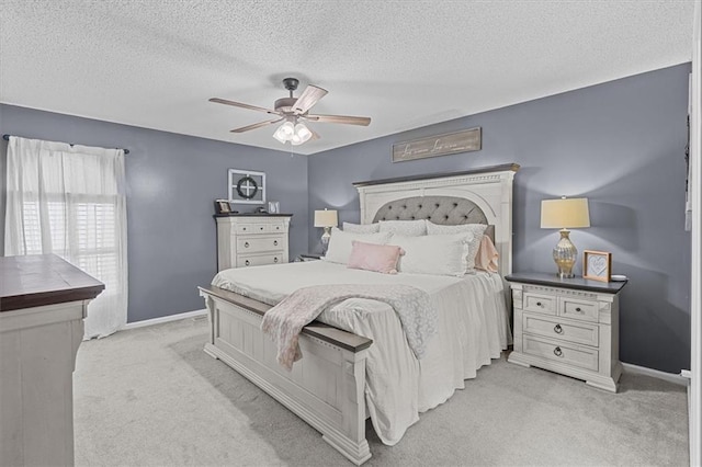 carpeted bedroom featuring a textured ceiling and ceiling fan