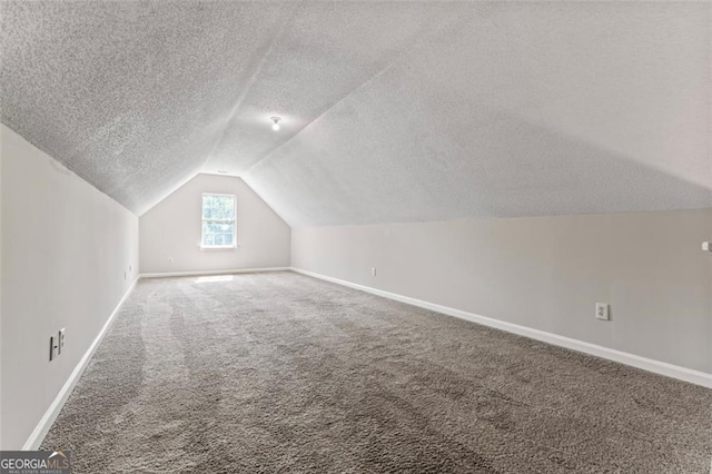 bonus room with carpet flooring, vaulted ceiling, a textured ceiling, and baseboards