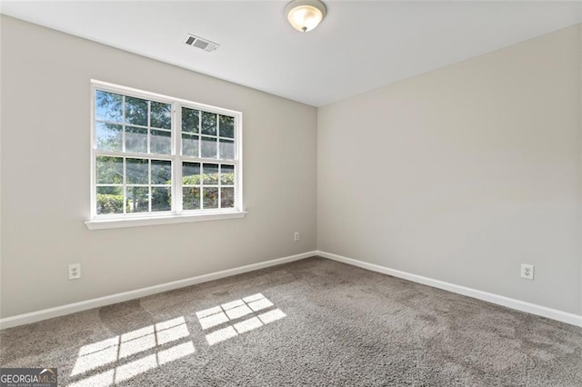 carpeted spare room with baseboards and visible vents