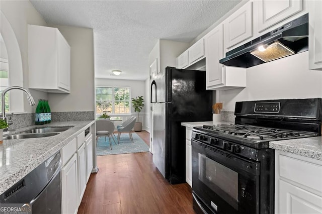 kitchen featuring black appliances, under cabinet range hood, white cabinetry, and a sink