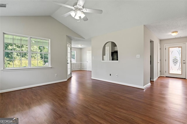 unfurnished living room featuring baseboards, visible vents, a ceiling fan, lofted ceiling, and dark wood-style flooring