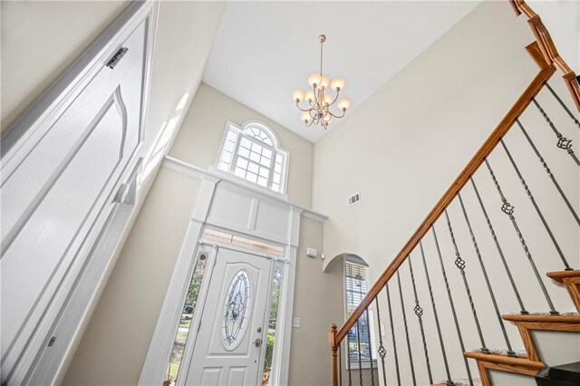 entrance foyer with a chandelier and high vaulted ceiling