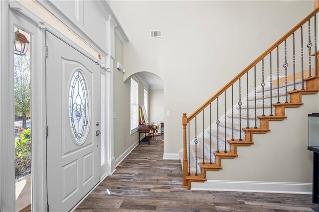 foyer entrance with dark hardwood / wood-style floors and ornamental molding