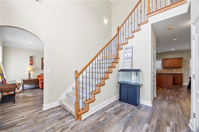 staircase featuring hardwood / wood-style floors and crown molding