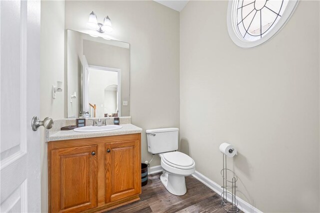 bathroom with vanity, toilet, and wood-type flooring