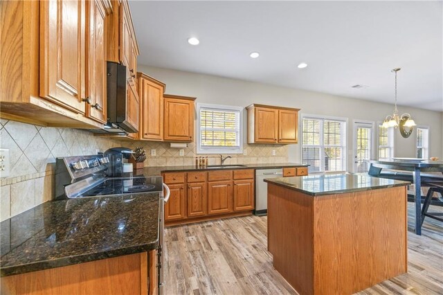 kitchen with a center island, stainless steel appliances, plenty of natural light, and light wood-type flooring