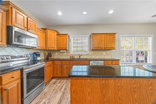 kitchen featuring a center island, stainless steel appliances, a wealth of natural light, and sink