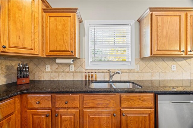 kitchen with tasteful backsplash, sink, dark stone counters, and stainless steel dishwasher