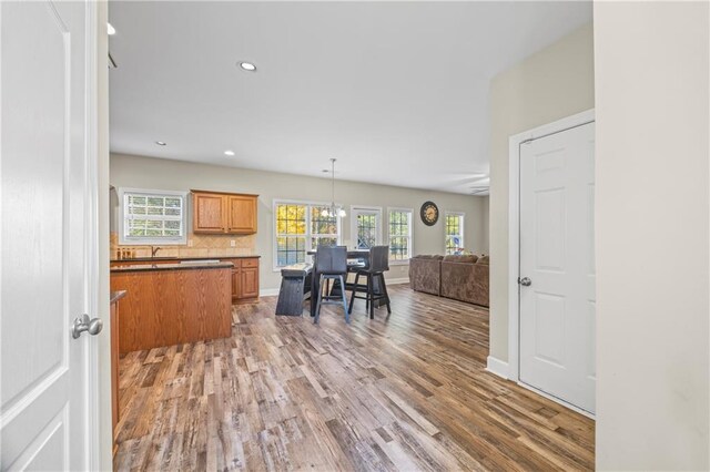 kitchen with backsplash, a wealth of natural light, decorative light fixtures, and dark hardwood / wood-style floors