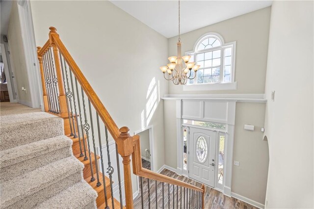 foyer entrance with hardwood / wood-style floors and a chandelier