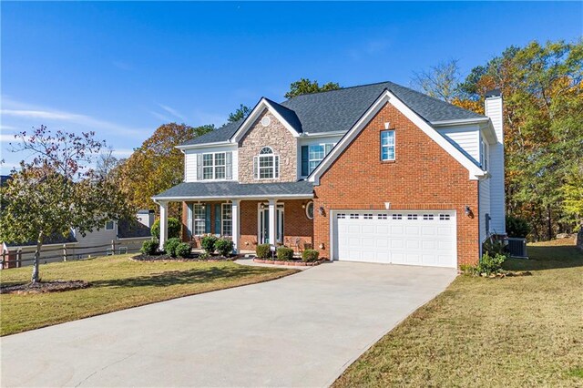 view of front of property with a porch, a garage, and a front lawn