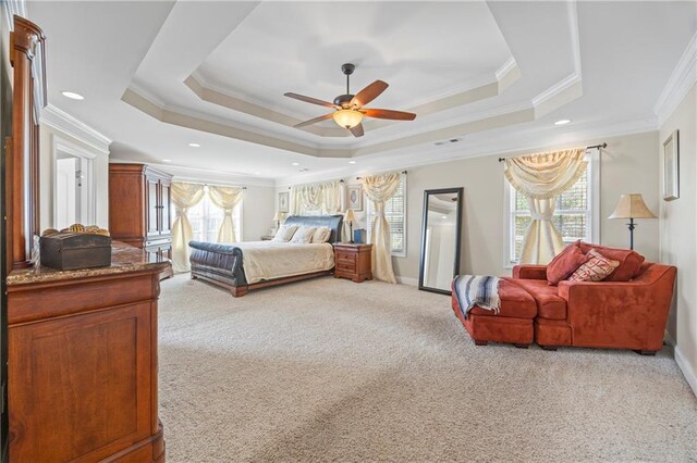 carpeted bedroom featuring multiple windows, a raised ceiling, ceiling fan, and crown molding