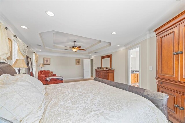 bedroom with ensuite bath, a raised ceiling, ceiling fan, and crown molding