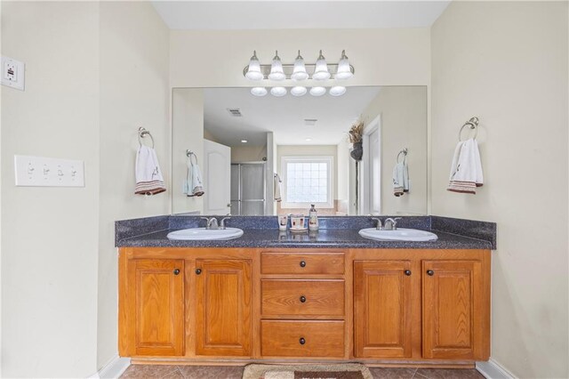 bathroom with tile patterned flooring, vanity, and a shower with shower door