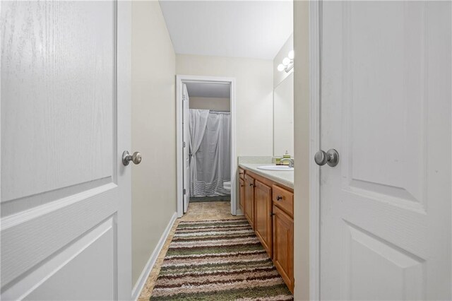 bathroom with tile patterned flooring, vanity, and toilet