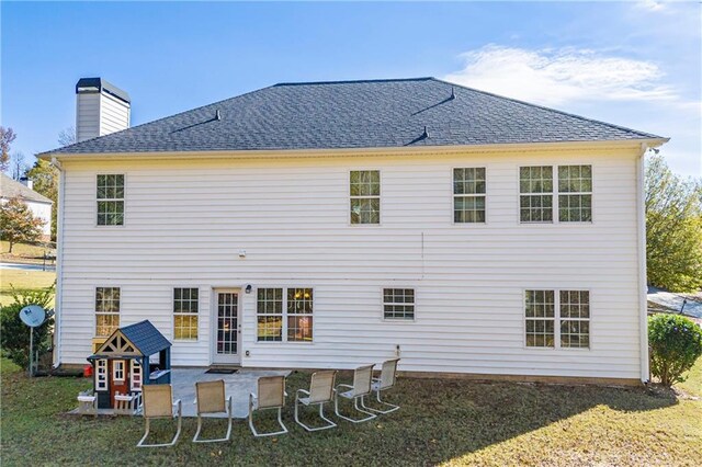 back of house with a yard and a patio