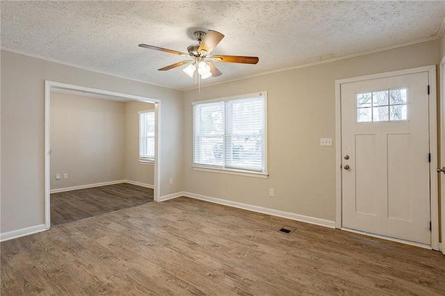 foyer with hardwood / wood-style flooring, ceiling fan, crown molding, and a textured ceiling